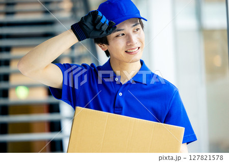 荷物を運ぶ男性配達員 荷物を運ぶ男性配達員 127821578