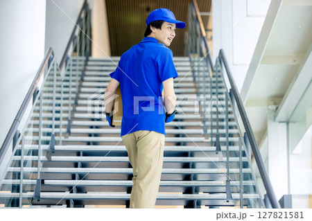 荷物を運ぶ男性配達員 荷物を運ぶ男性配達員 127821581