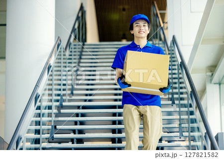 荷物を運ぶ男性配達員 127821582