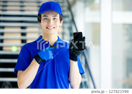 スマホを持つ配達員 127821590