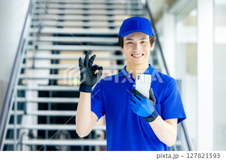 スマホを持つ配達員 127821593