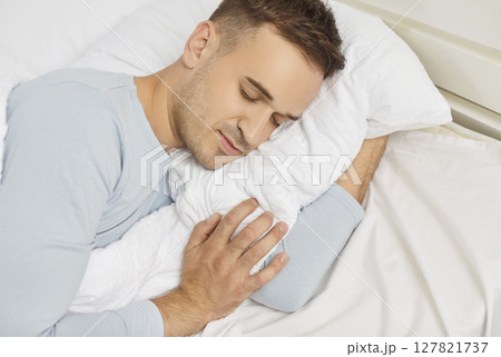 Close up of young man sleeping in sweet dreams on bed in the morning at home. Close up of young man sleeping in sweet dreams on bed in the morning at home. 127821737
