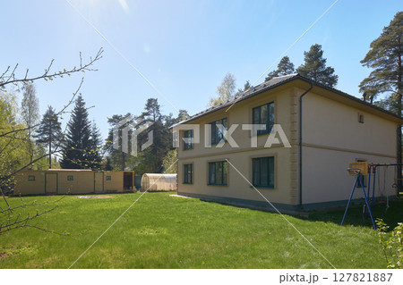 A Beautiful TwoStory House Featuring a Spacious Garden and Inviting Outdoor Relaxation Spaces 127821887