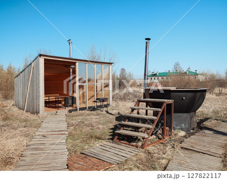 A Rustic Outdoor Retreat featuring a charming Wooden Cabin and a relaxing Bathing Area to enjoy 127822117