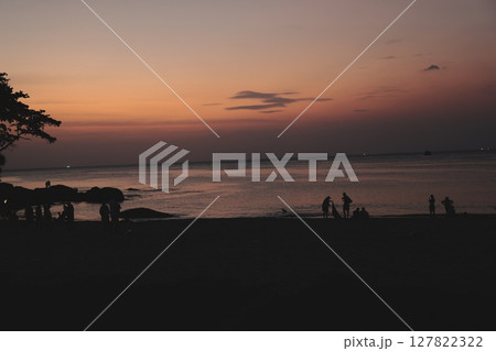 A Serene and Beautiful Sunset at the Beach with Stunning Silhouettes of People Gathered A Serene and Beautiful Sunset at the Beach with Stunning Silhouettes of People Gathered 127822322