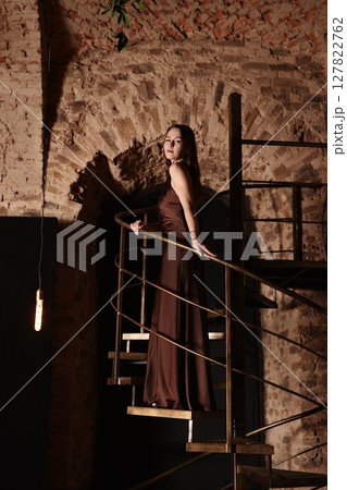 An Elegant Woman Posing Gracefully on an Artistic Structure in a Distinctive and Unique Setting 127822762
