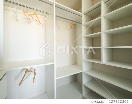 A Modern and Empty Closet Featuring Shelves and Hangers for Optimal Organization and Style 127822805