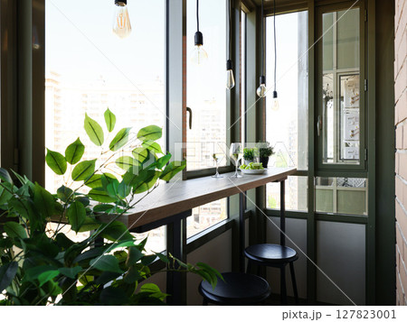 A Modern Balcony Design Featuring Lush Greenery and Comfortable, Cozy Seating Options 127823001