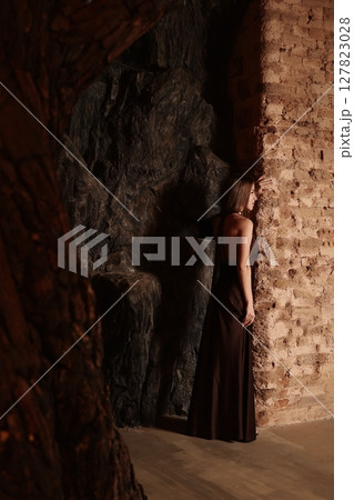 A Mysterious Figure Lying in Serenity within a Dim Cave Environment Reflected in Shadows and Light A Mysterious Figure Lying in Serenity within a Dim Cave Environment Reflected in Shadows and Light 127823028