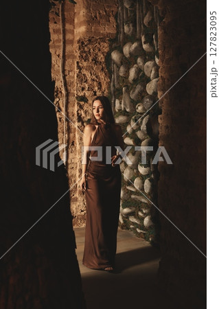 A Mysterious Woman Elegantly Dressed in Earthy Tones and Hues Captivating the Eye A Mysterious Woman Elegantly Dressed in Earthy Tones and Hues Captivating the Eye 127823095