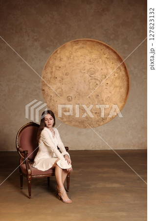 Enchanting Fantasy Portrait Featuring a Captivating Moon Motif and a Stylish Vintage Chair 127823132