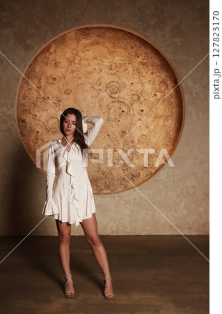 An Elegant Woman Posing Gracefully in Front of a Beautiful and Artistic Background 127823170