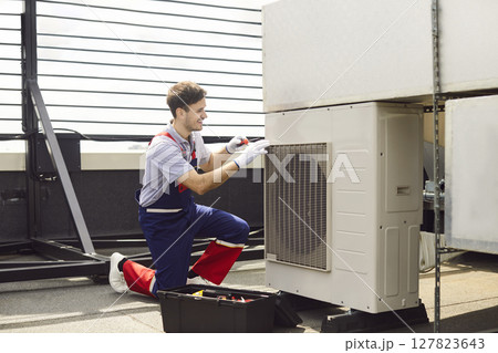 Repairman Inspecting And Fixing Hvac Air Conditioner On Roof 127823643