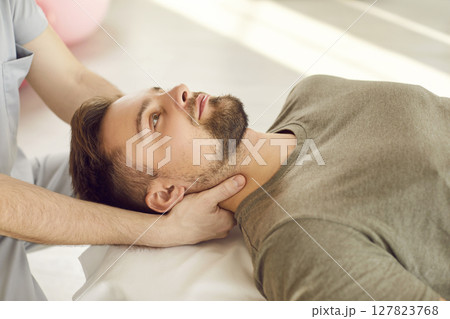 Therapist Or Masseur Stretching Patient's Neck During Rehabilitation Therapist Or Masseur Stretching Patient's Neck During Rehabilitation 127823768