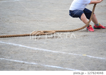 全力で綱引きをする小学生の足元 127824048