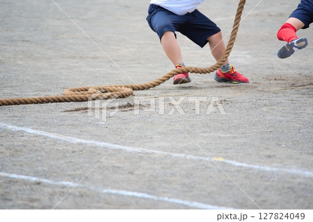 全力で綱引きをする小学生の足元 127824049