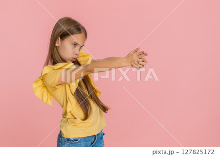 Child girl kid enthusiastically points finger like gun smiles cheerfully while looking right 127825172