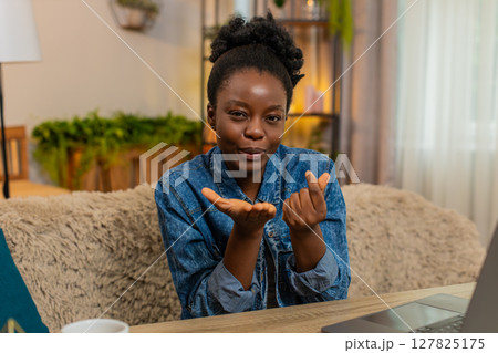 African American young woman sends air kiss into camera smiling playfully flirty expression at home 127825175
