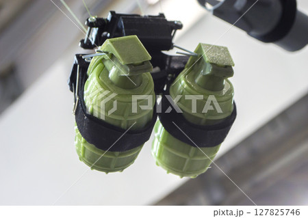 Hanging grenade. Grenade printed on 3D printer from melted plastic. Plastic grenade created on 3D printer. Prototype of ammunition printed on 3D printer. Innovation 3d printing. Innovation technology Hanging grenade. Grenade printed on 3D printer from melted plastic. Plastic grenade created on 3D printer. Prototype of ammunition printed on 3D printer. Innovation 3d printing. Innovation technology 127825746