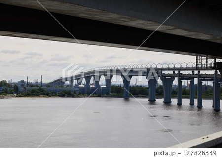 A Modern Bridge Spanning Over Water with a Beautiful Urban Landscape in the Background A Modern Bridge Spanning Over Water with a Beautiful Urban Landscape in the Background 127826339