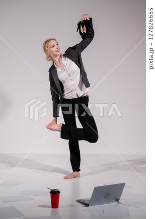 Barefoot ballerina dancing in business suit on white background.  127826655