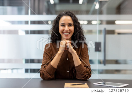 Webcam view, online video presentation seminar meeting, young successful woman looking at camera while sitting at desk inside office. Conference with partners and clients businesswoman smiling. 127826759