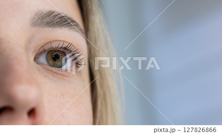 Close-up of a woman's eye after eyelash lamination procedure. Close-up of a woman's eye after eyelash lamination procedure. 127826866
