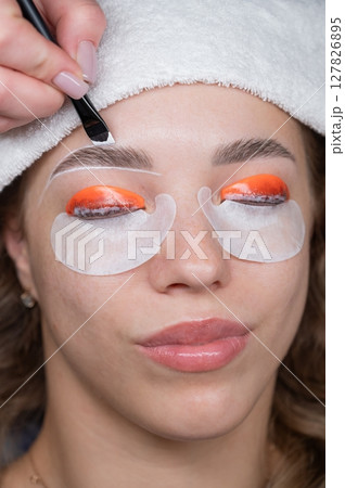 The process of professional lamination and dyeing of eyelashes and eyebrows in the salon. The process of professional lamination and dyeing of eyelashes and eyebrows in the salon. 127826895