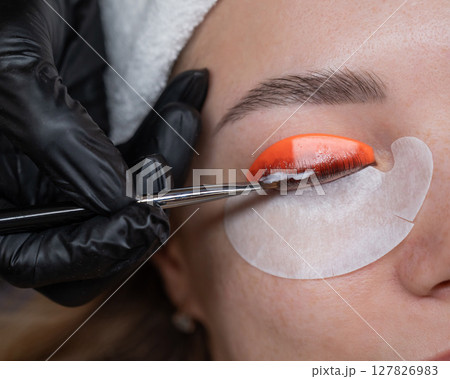 Caucasian woman undergoing eyelash lamination procedure. Caucasian woman undergoing eyelash lamination procedure. 127826983