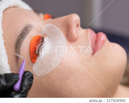 Caucasian woman undergoing eyelash lamination procedure.  127826992