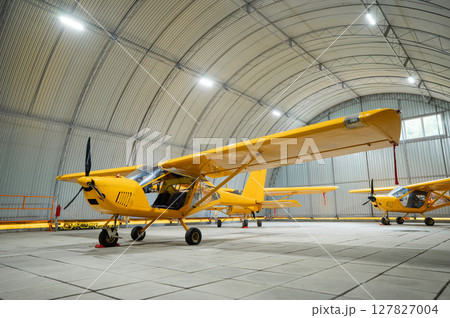Yellow airplane glider in the hangar.  127827004