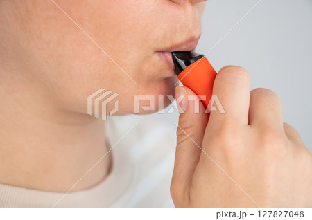 Caucasian woman smoking disposable vape. Caucasian woman smoking disposable vape. 127827048