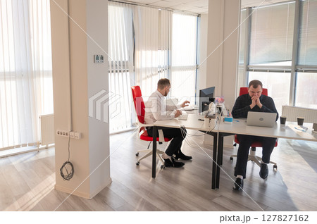 Two Caucasian men working in an office.  127827162