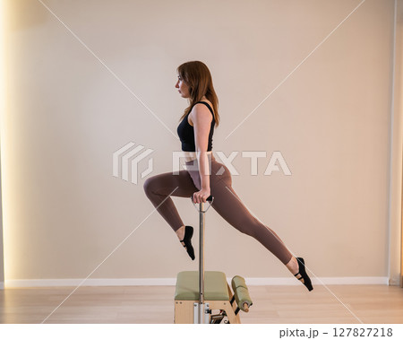 Asian woman doing pilates classic chair. Asian woman doing pilates classic chair. 127827218
