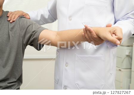 Physical therapy, Asian therapist doctor treat perform pain young man in hospital. Physical therapy, Asian therapist doctor treat perform pain young man in hospital. 127827267