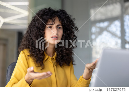 Serious and anxious woman talking to colleagues and partners sitting at desk with laptop, using video call, for remote business conference meeting. Serious and anxious woman talking to colleagues and partners sitting at desk with laptop, using video call, for remote business conference meeting. 127827973