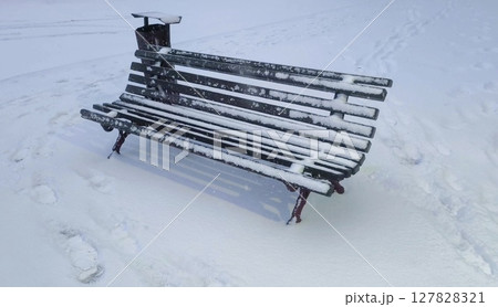 snowstorm in courtyard with bench. winter during snow in a courtyard in the city. Winter weather, december. atmospheric video, a lonely bench covered in snow. snowstorm in courtyard with bench. winter during snow in a courtyard in the city. Winter weather, december. atmospheric video, a lonely bench covered in snow. 127828321