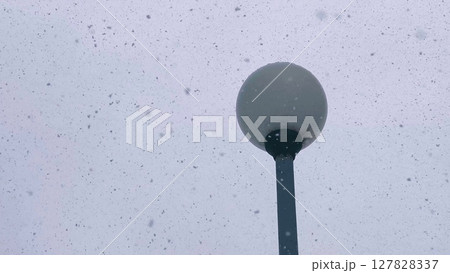 lamppost during snowfall in winter. winter snowstorm on the background of a lamppost in daytime. Blizzard in winter. lamppost during snowfall in winter. winter snowstorm on the background of a lamppost in daytime. Blizzard in winter. 127828337