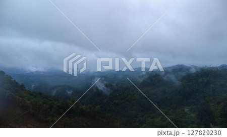 Amazing natural scenery of mist rising from the forest after rain. Aerial view of the majestic mist forest. Amazing natural scenery of mist rising from the forest after rain. Aerial view of the majestic mist forest. 127829230