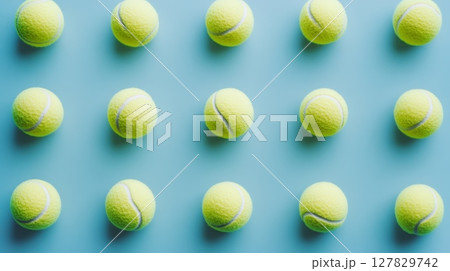 Many tennis balls are creating a repeating pattern on a light blue background, representing sport, order, and precision 127829742