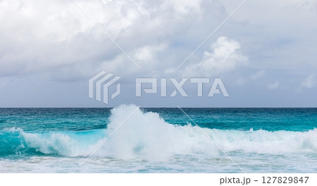 Mahe island, Seychelles. Dynamic ocean waves are under cloudy sky Mahe island, Seychelles. Dynamic ocean waves are under cloudy sky 127829847