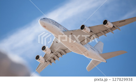 Large passenger airplane in flight against clear blue sky 127829938