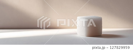 Sugar cube on a white surface with a shadow, symbolizing sugar in diets and promoting sugar free living 127829959