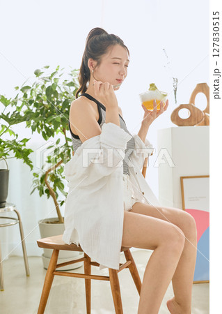 かき氷を食べて夏を楽しむ笑顔の若い女性のライフスタイル 127830515