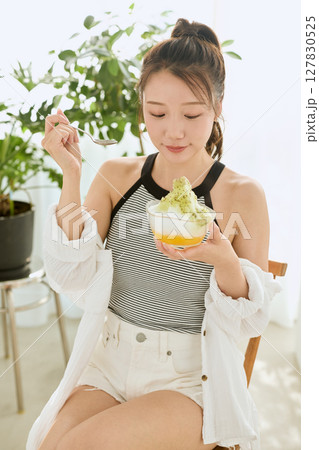 かき氷を食べて夏を楽しむ笑顔の若い女性のライフスタイル 127830525