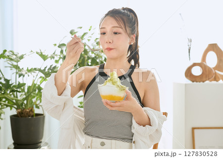 かき氷を食べて夏を楽しむ笑顔の若い女性のライフスタイル 127830528