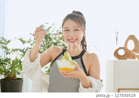 かき氷を食べて夏を楽しむ笑顔の若い女性のライフスタイル 127830529