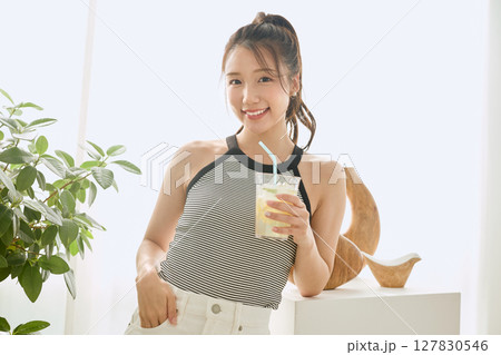 部屋ででレモネードを飲む夏の爽やかな若い女性 部屋ででレモネードを飲む夏の爽やかな若い女性 127830546