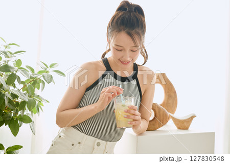 部屋ででレモネードを飲む夏の爽やかな若い女性 127830548