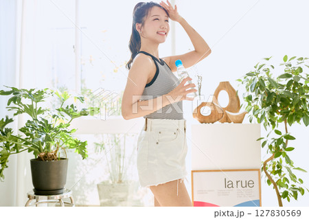 部屋ででラムネを楽しむ夏の爽やかな若い女性の笑顔 127830569